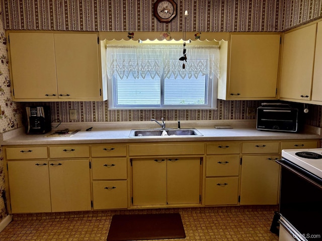 215 Day St, Ironwood, MI 49938 - kitchen featuring a sink, wallpapered walls, light countertops, and plenty of natural light