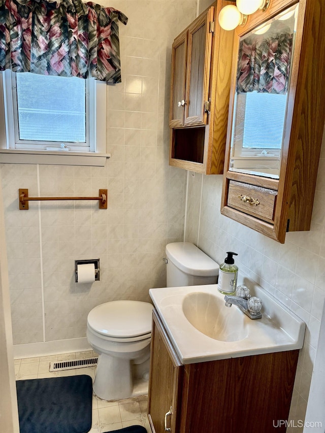 215 Day St, Ironwood, MI 49938 - bathroom featuring vanity, toilet, plenty of natural light, tile walls, and tile patterned flooring