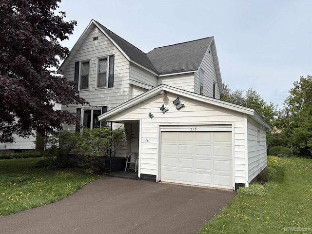 215 Day St, Ironwood, MI 49938 - view of front of house with roof with shingles, a front lawn, a garage, asphalt driveway, and an outbuilding