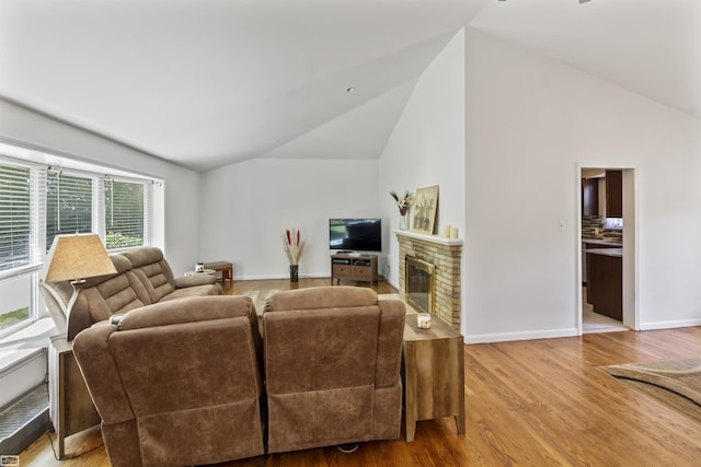 42910 Utica Rd, Sterling Heights, MI 48314 - living area with wood finished floors, a glass covered fireplace, high vaulted ceiling, and baseboards