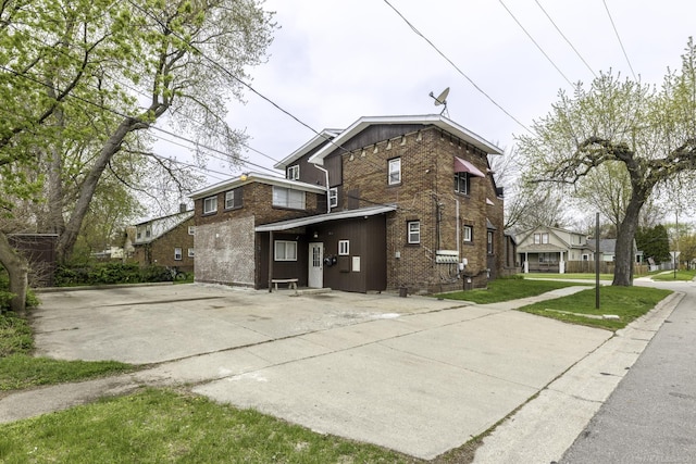 1104 Minnie St, Port Huron, MI 48060 - back of house featuring concrete driveway, brick siding, and board and batten siding
