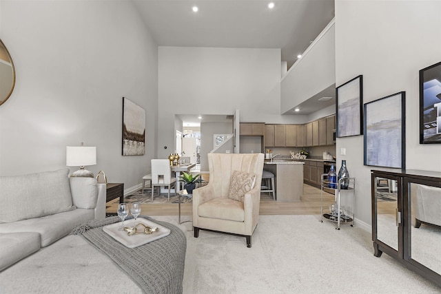 2215 Chase Dr Unit 102, Howell, MI 48855 - living area featuring a high ceiling, recessed lighting, baseboards, and light carpet