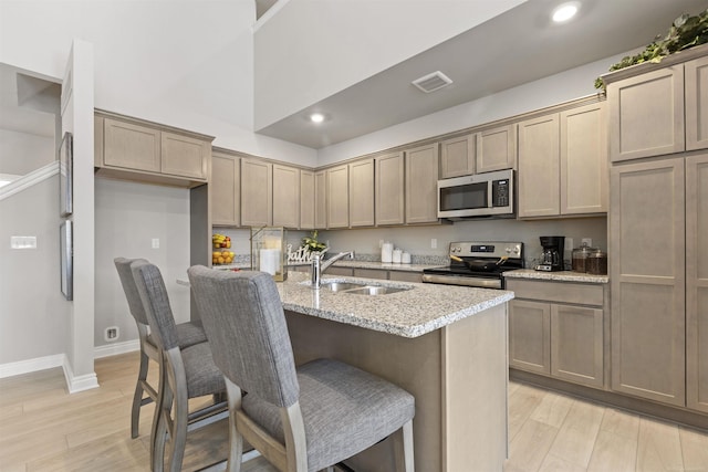 2215 Chase Dr Unit 102, Howell, MI 48855 - kitchen featuring stainless steel appliances, a sink, light stone counters, light wood-style floors, and recessed lighting