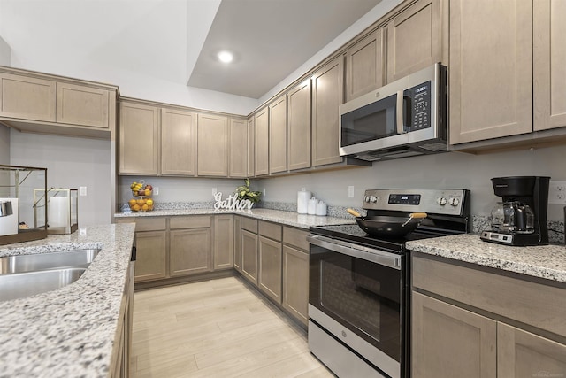 2215 Chase Dr Unit 102, Howell, MI 48855 - kitchen featuring appliances with stainless steel finishes, light wood-type flooring, recessed lighting, light stone countertops, and a sink