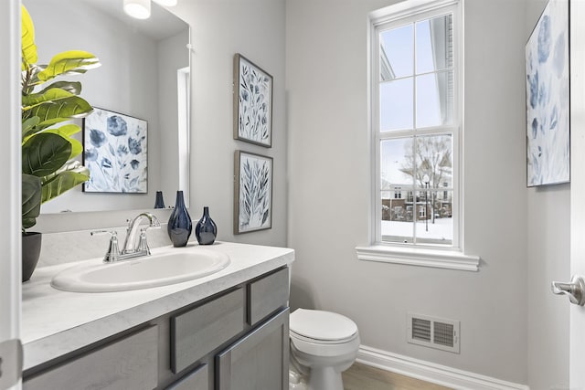 2215 Chase Dr Unit 102, Howell, MI 48855 - bathroom featuring vanity, toilet, and baseboards