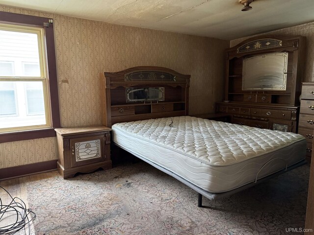 336 E Broad St, Lanse, MI 49946 - bedroom featuring wood finished floors, baseboards, and wallpapered walls