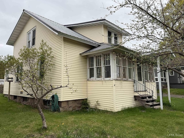 336 E Broad St, Lanse, MI 49946 - view of property exterior with metal roof and a lawn