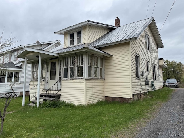 336 E Broad St, Lanse, MI 49946 - view of front of home with a chimney, metal roof, and a front lawn
