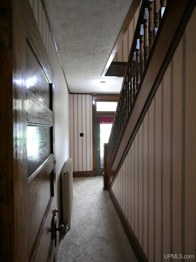 909 Quincy St, Hancock, MI 49930 - hall featuring radiator heating unit, carpet flooring, stairway, a textured ceiling, and baseboards
