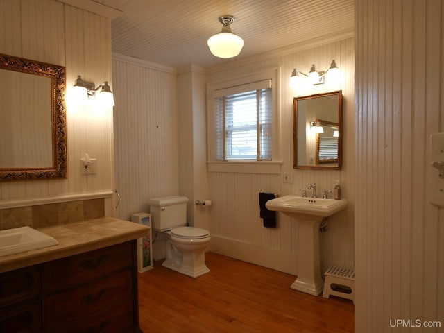 909 Quincy St, Hancock, MI 49930 - bathroom featuring wood finished floors, toilet, a sink, and ornamental molding