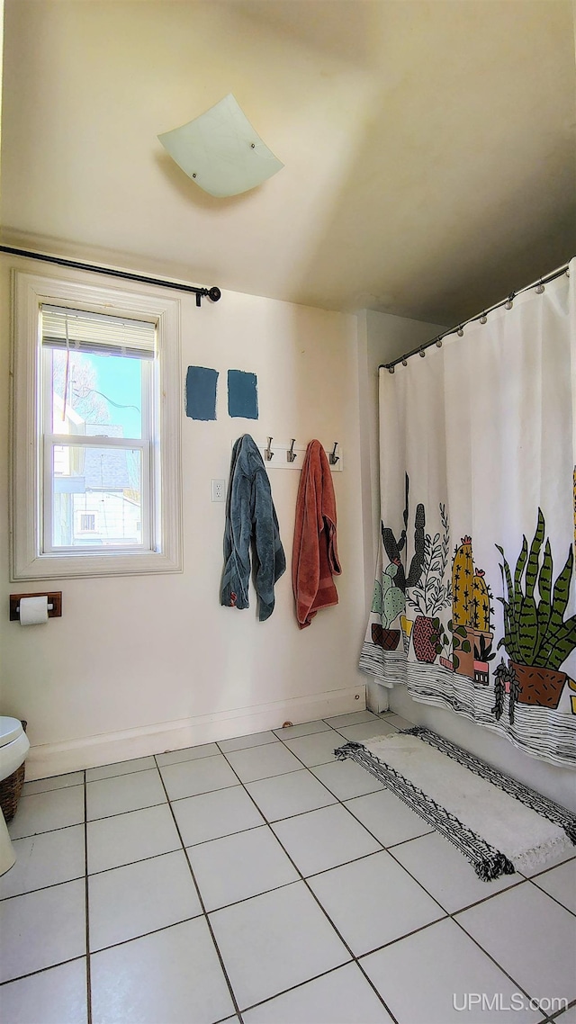 304 E Lincoln St, Negaunee, MI 49866 - full bath featuring tile patterned flooring, baseboards, toilet, and curtained shower