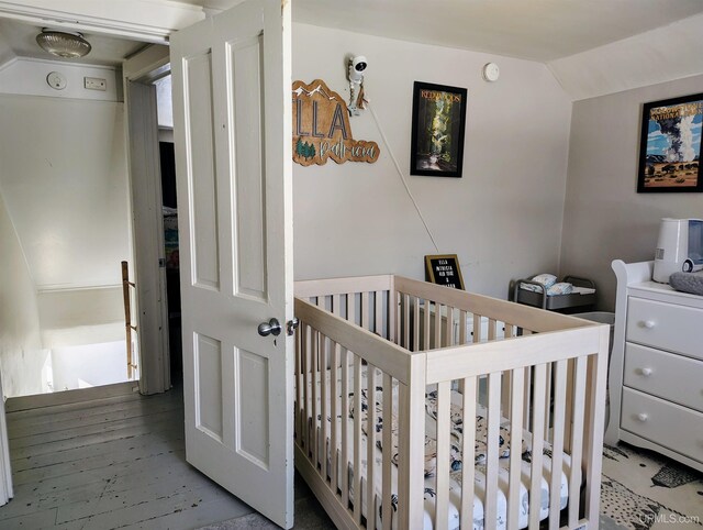 304 E Lincoln St, Negaunee, MI 49866 - bedroom with a nursery area, lofted ceiling, and wood finished floors