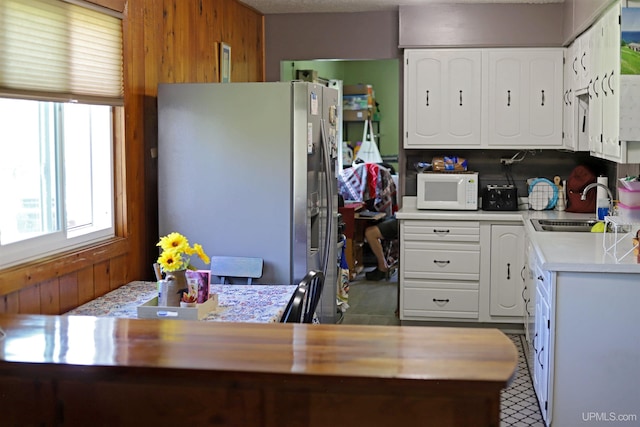5631 County Road 550th Rd, Marquette, MI 49855 - kitchen with freestanding refrigerator, a sink, white microwave, wood walls, and light countertops
