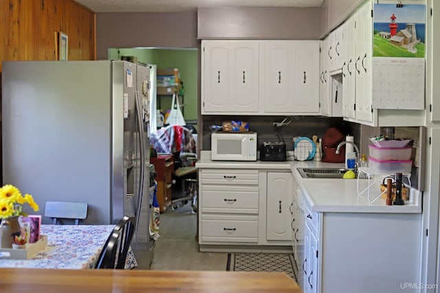 5631 County Road 550th Rd, Marquette, MI 49855 - kitchen featuring stainless steel fridge with ice dispenser, a sink, white microwave, light countertops, and white cabinets
