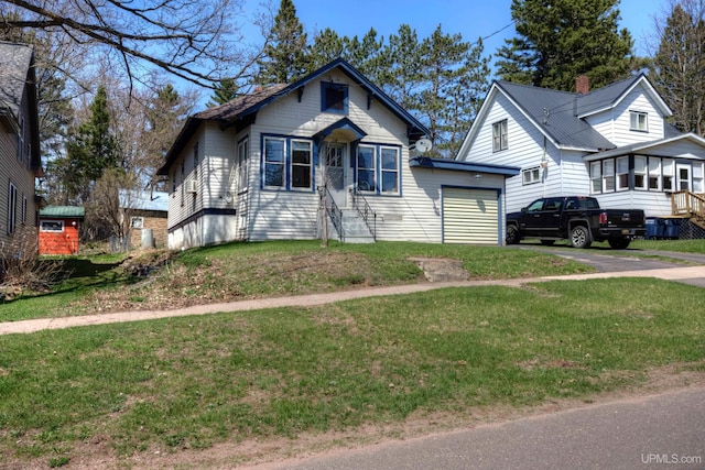 338 E Tamarack St, Ironwood, MI 49938 - bungalow-style home with a garage, asphalt driveway, a front lawn, a chimney, and entry steps