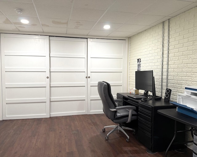 5266 Brook Hollow Ave, Bay City, MI 48706 - office area featuring brick wall, a paneled ceiling, and dark wood-type flooring