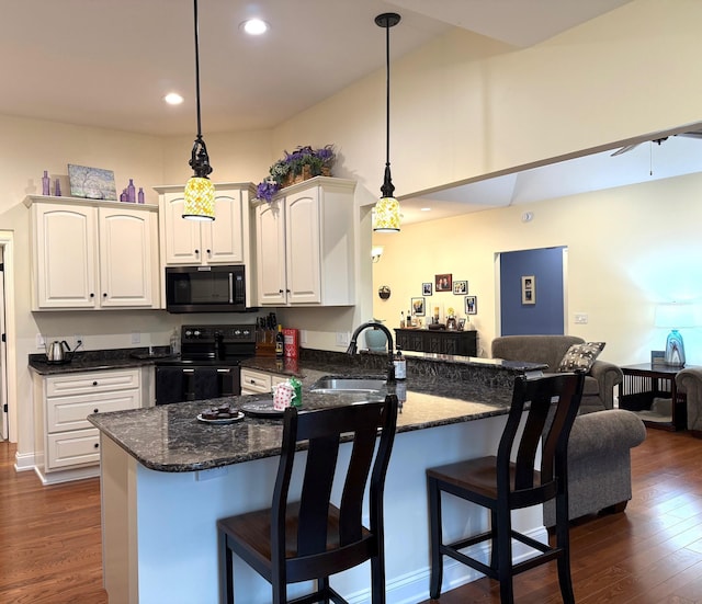 5266 Brook Hollow Ave, Bay City, MI 48706 - kitchen with black range with electric stovetop, a sink, dark wood-style flooring, a peninsula, and a kitchen breakfast bar