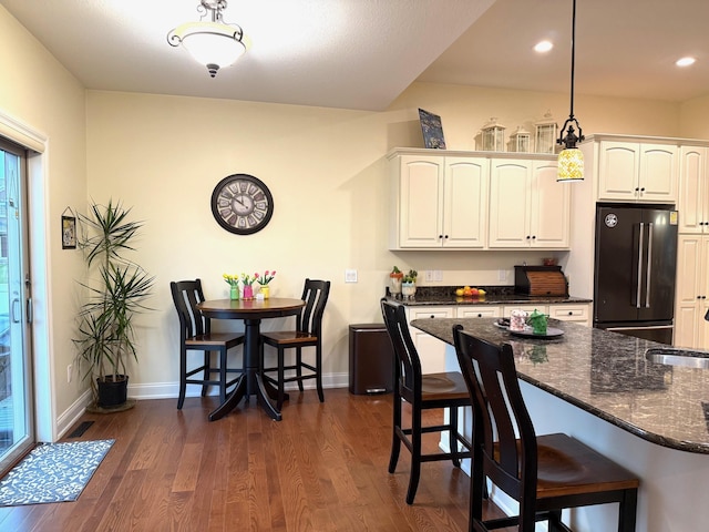 5266 Brook Hollow Ave, Bay City, MI 48706 - kitchen with high quality fridge, a kitchen breakfast bar, dark wood-style floors, white cabinetry, and recessed lighting
