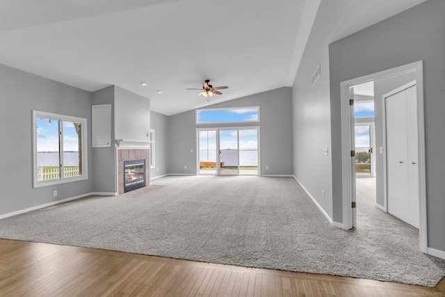 38340 Lakeshore Dr, Harrison Twp, MI 48045 - unfurnished living room featuring a tile fireplace, healthy amount of natural light, baseboards, a ceiling fan, and lofted ceiling