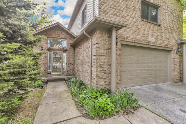 38340 Lakeshore Dr, Harrison Twp, MI 48045 - view of exterior entry with brick siding, driveway, and an attached garage