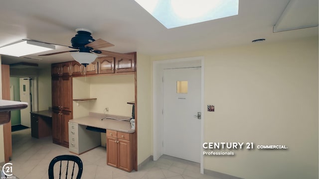 2884 Fort St, Lincoln Park, MI 48146 - kitchen with a ceiling fan, brown cabinetry, a skylight, an office area, and light tile patterned floors
