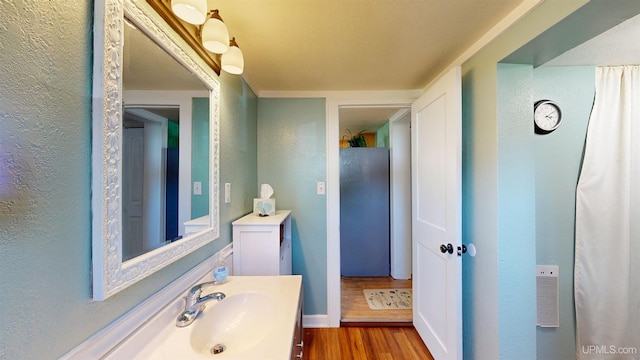 422 Washington St, Ishpeming, MI 49849 - bathroom with wood finished floors, a textured wall, vanity, and baseboards