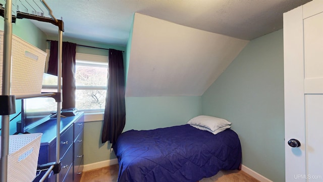 422 Washington St, Ishpeming, MI 49849 - carpeted bedroom with vaulted ceiling, baseboards, and a textured ceiling