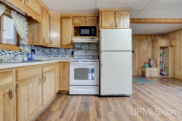 1782 H Rd, Bark River, MI 49807 - kitchen with white appliances, under cabinet range hood, tasteful backsplash, light countertops, and wooden walls