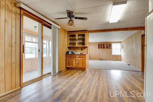 1782 H Rd, Bark River, MI 49807 - unfurnished living room with light wood-type flooring, wooden walls, and ceiling fan