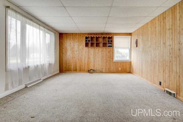 1782 H Rd, Bark River, MI 49807 - unfurnished room featuring plenty of natural light, wood walls, baseboards, carpet flooring, and a paneled ceiling