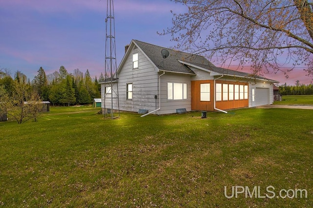 1782 H Rd, Bark River, MI 49807 - property exterior at dusk featuring a garage, a yard, and driveway