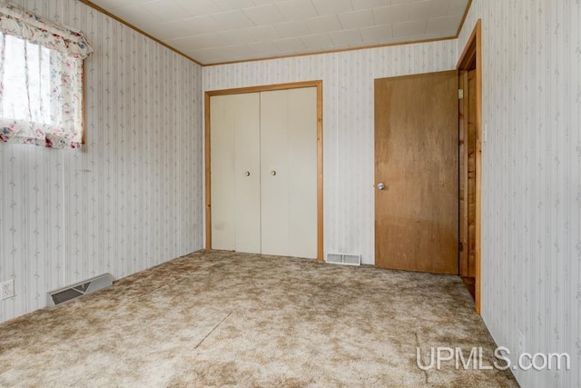 1782 H Rd, Bark River, MI 49807 - unfurnished bedroom featuring ornamental molding, carpet flooring, wallpapered walls, and a closet