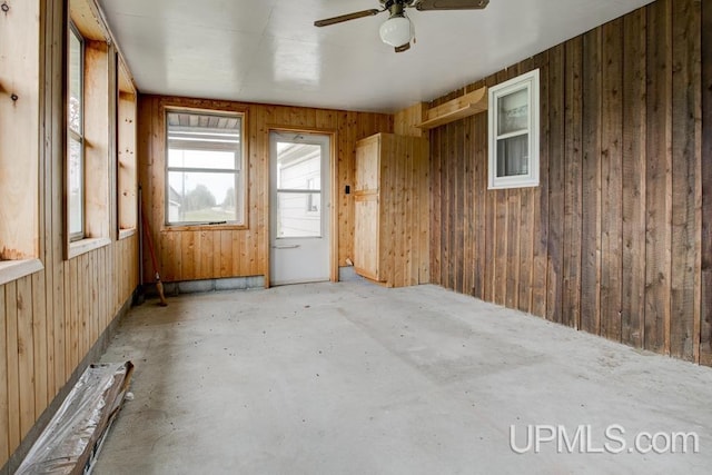 1782 H Rd, Bark River, MI 49807 - spare room with wood walls, concrete flooring, and ceiling fan