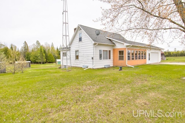 1782 H Rd, Bark River, MI 49807 - view of side of home with an attached garage, concrete driveway, a yard, and roof with shingles
