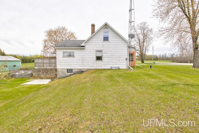 1782 H Rd, Bark River, MI 49807 - rear view of house featuring a chimney, a yard, and roof with shingles