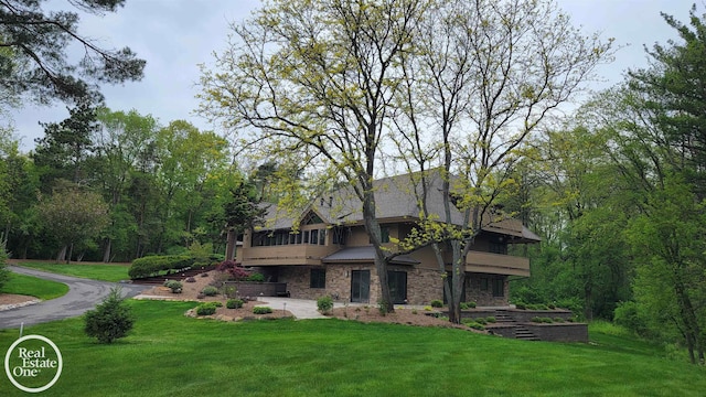 966 Pine Needle Trl, Oakland Twp, MI 48306 - rear view of property featuring a yard, stone siding, and a patio