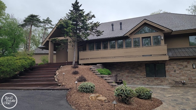 966 Pine Needle Trl, Oakland Twp, MI 48306 - view of front of property with stairway, stone siding, a patio, and a shingled roof