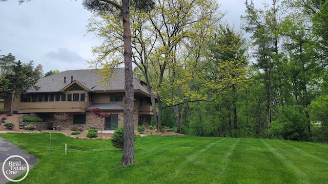966 Pine Needle Trl, Oakland Twp, MI 48306 - view of front of property with a front lawn, stone siding, a sunroom, and metal roof
