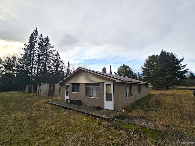 10162 Wyoming Rd, Mohawk, MI 49918 - view of property exterior featuring concrete block siding and a chimney