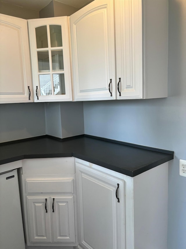 3214 Elnor Dr, Gladwin, MI 48624 - kitchen featuring dark countertops, dishwasher, white cabinets, and glass insert cabinets