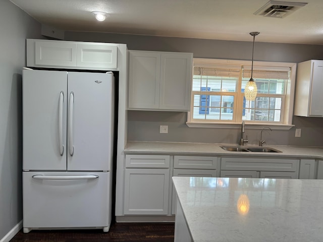 3214 Elnor Dr, Gladwin, MI 48624 - kitchen with freestanding refrigerator, a sink, white cabinets, and pendant lighting