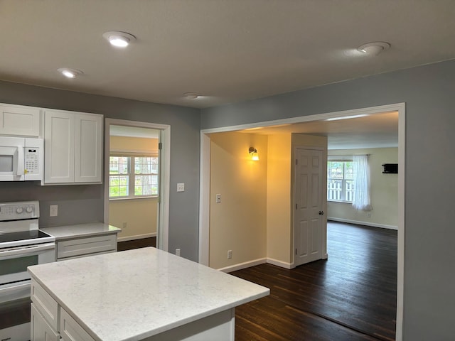 3214 Elnor Dr, Gladwin, MI 48624 - kitchen with white appliances, baseboards, dark wood-type flooring, white cabinets, and a kitchen island
