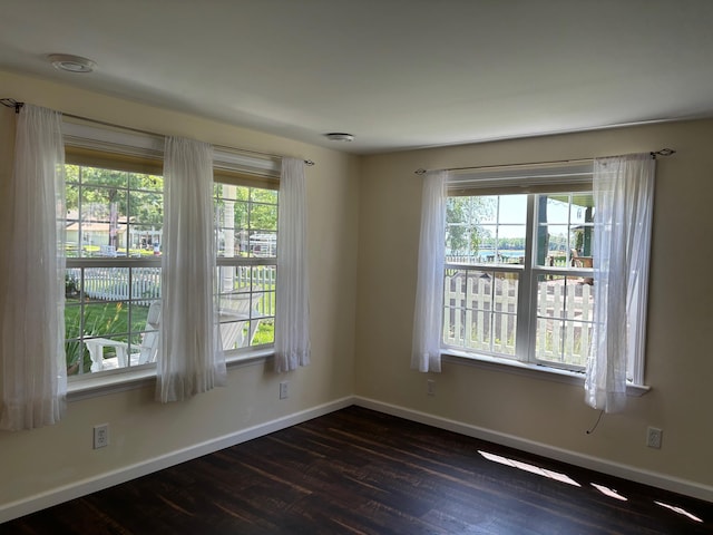 3214 Elnor Dr, Gladwin, MI 48624 - unfurnished room with dark wood-style flooring, baseboards, and healthy amount of natural light
