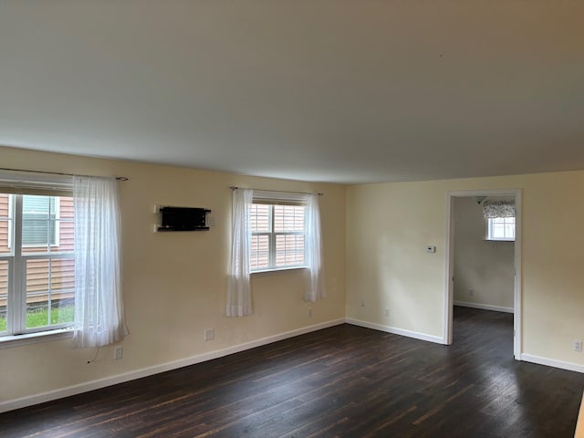 3214 Elnor Dr, Gladwin, MI 48624 - spare room featuring healthy amount of natural light, dark wood-type flooring, and baseboards