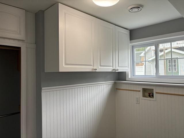 3214 Elnor Dr, Gladwin, MI 48624 - laundry room featuring hookup for a washing machine, cabinet space, a wainscoted wall, and a decorative wall