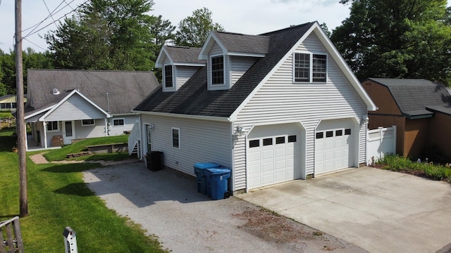 3214 Elnor Dr, Gladwin, MI 48624 - view of home's exterior with driveway, a yard, a garage, and roof with shingles