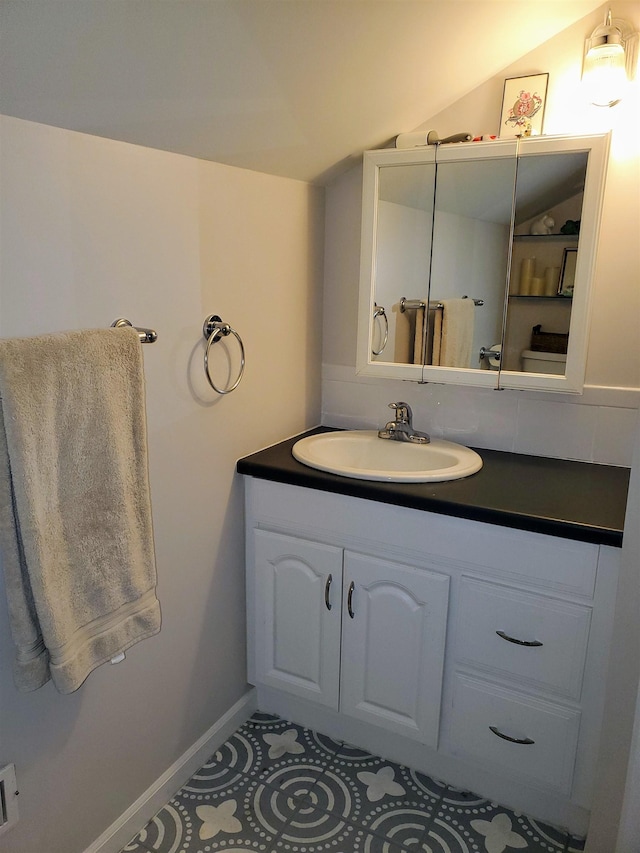 3214 Elnor Dr, Gladwin, MI 48624 - bathroom featuring lofted ceiling, vanity, and baseboards