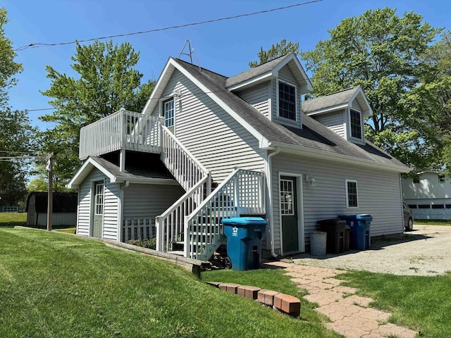 3214 Elnor Dr, Gladwin, MI 48624 - view of home's exterior with a yard, a deck, stairs, and roof with shingles