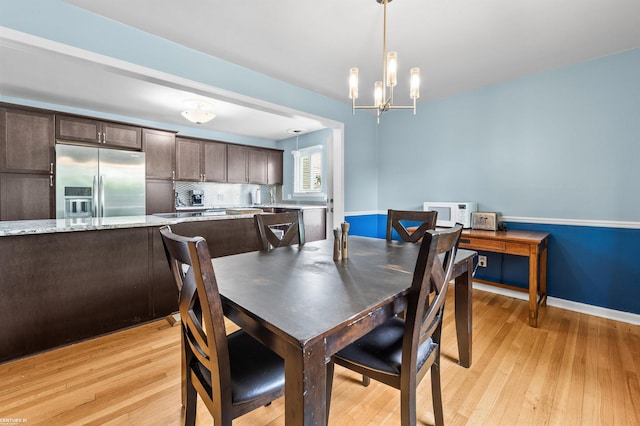8912 Hubbard St, Livonia, MI 48150 - dining area featuring a chandelier, light wood-type flooring, and baseboards