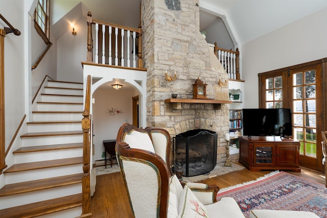 7975 00.25 Rd, Garden, MI 49835 - living area featuring high vaulted ceiling, stairway, wood finished floors, and a fireplace